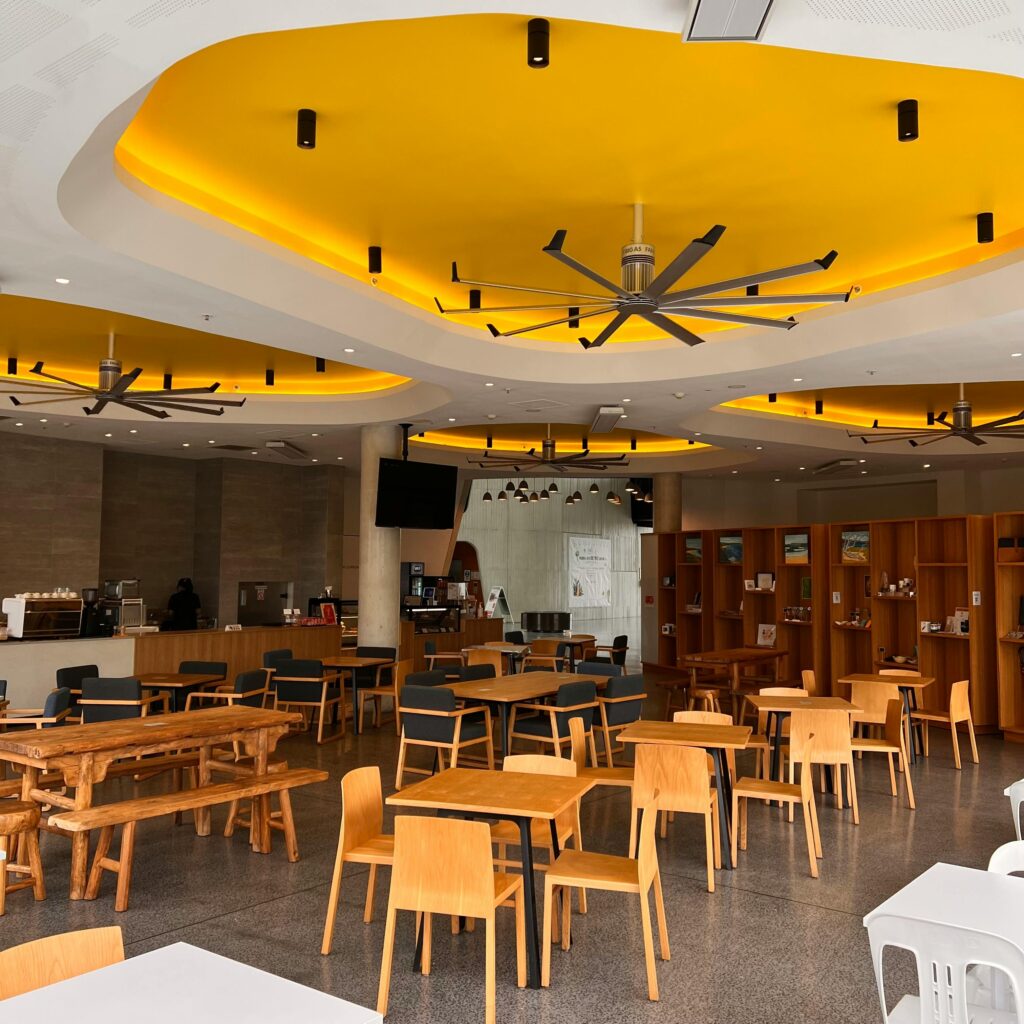Stylish restaurant interior featuring a striking yellow ceiling design with modern furniture.